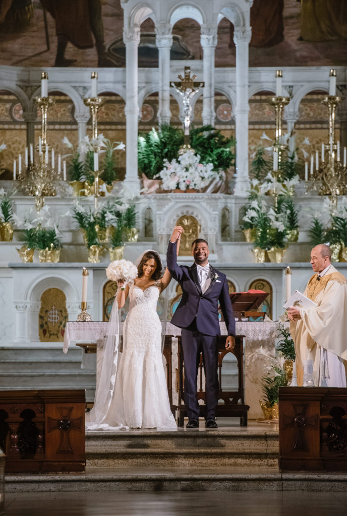 Newly married couple celebrates their announcement as “husband and wife” at their New Orleans wedding ceremony.
