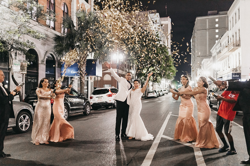The wedding party celebrates in the street.