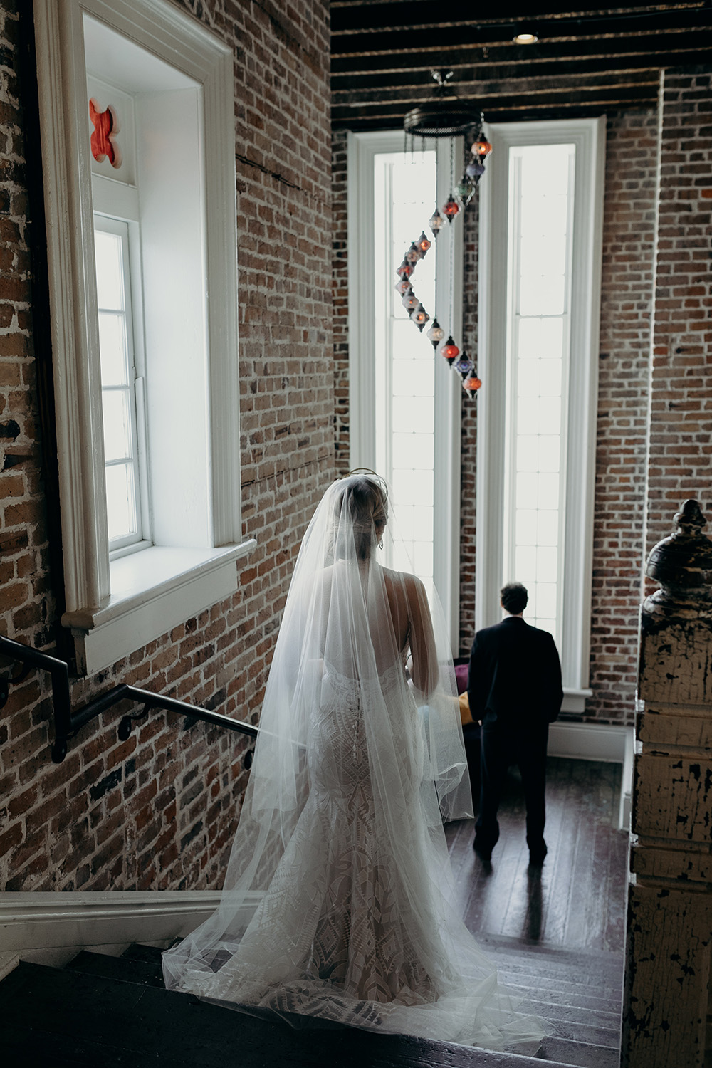 Ashley walks down the stairs at Felicity Church for the first look as Peter waits on the landing.