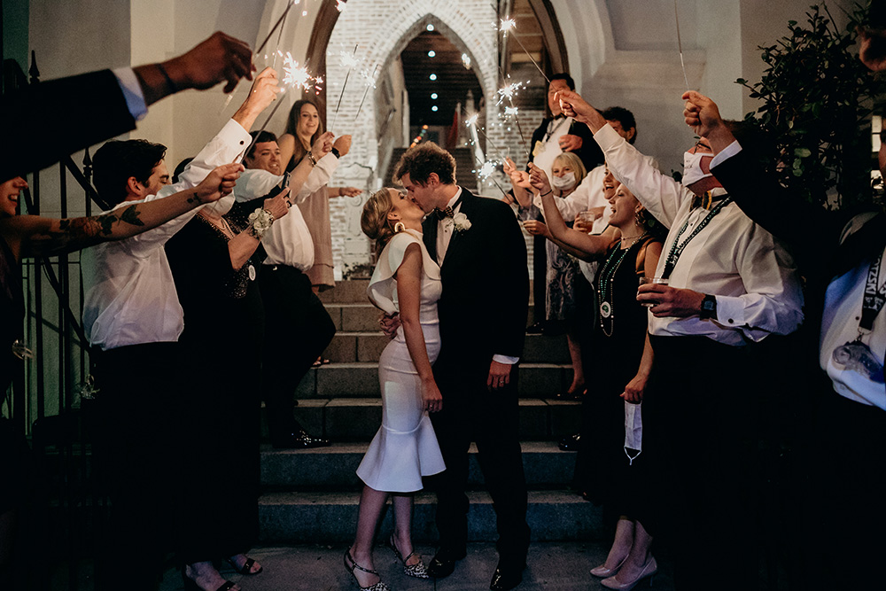 Ashley and Peter kiss as they exit Felicity Church while guests light the way with sparklers.
