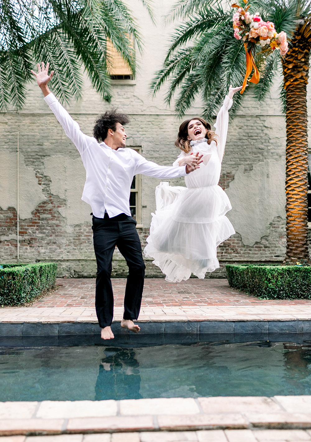 Bride and groom jump into swimming pool