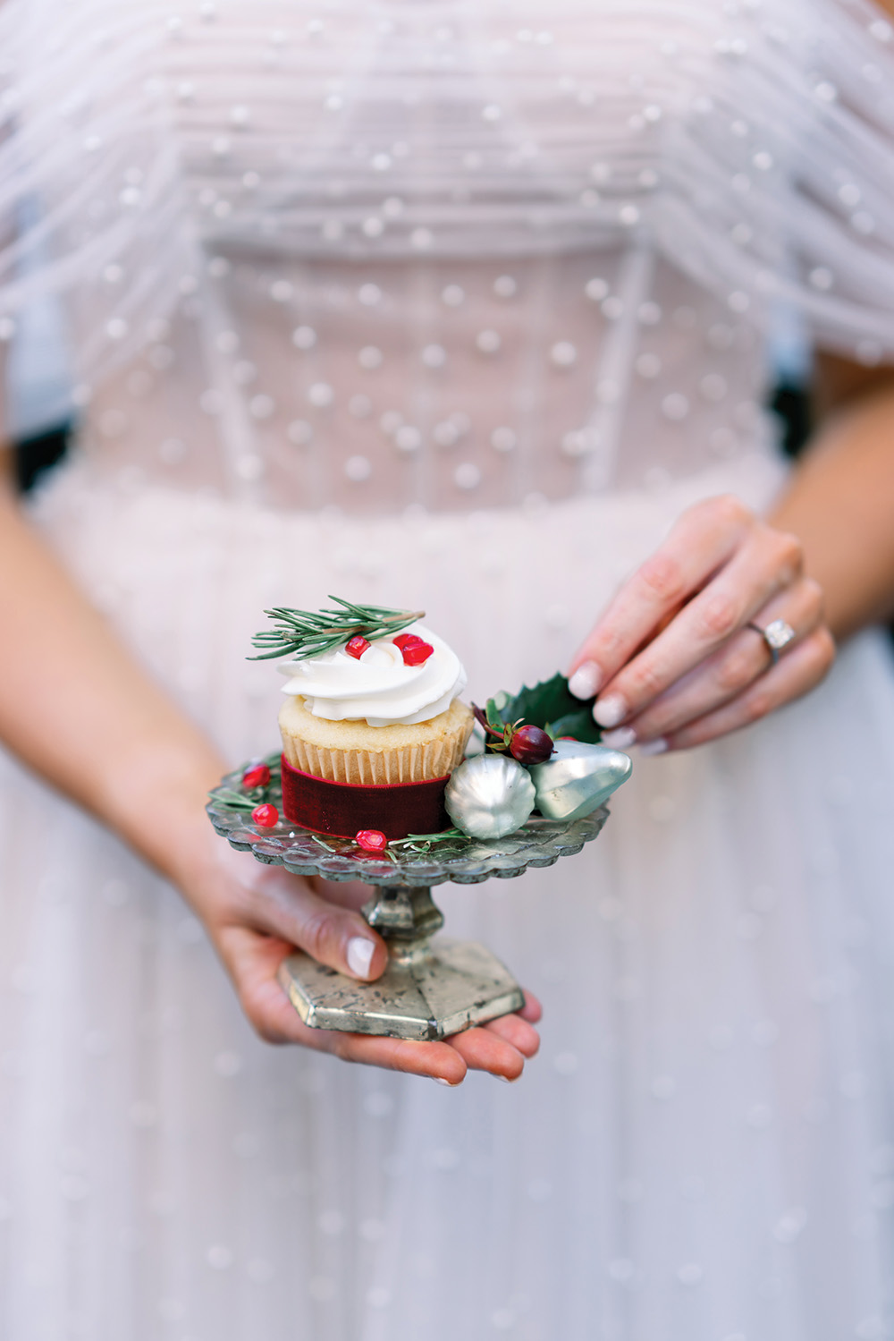 Bride holding Christmas wedding cupcake