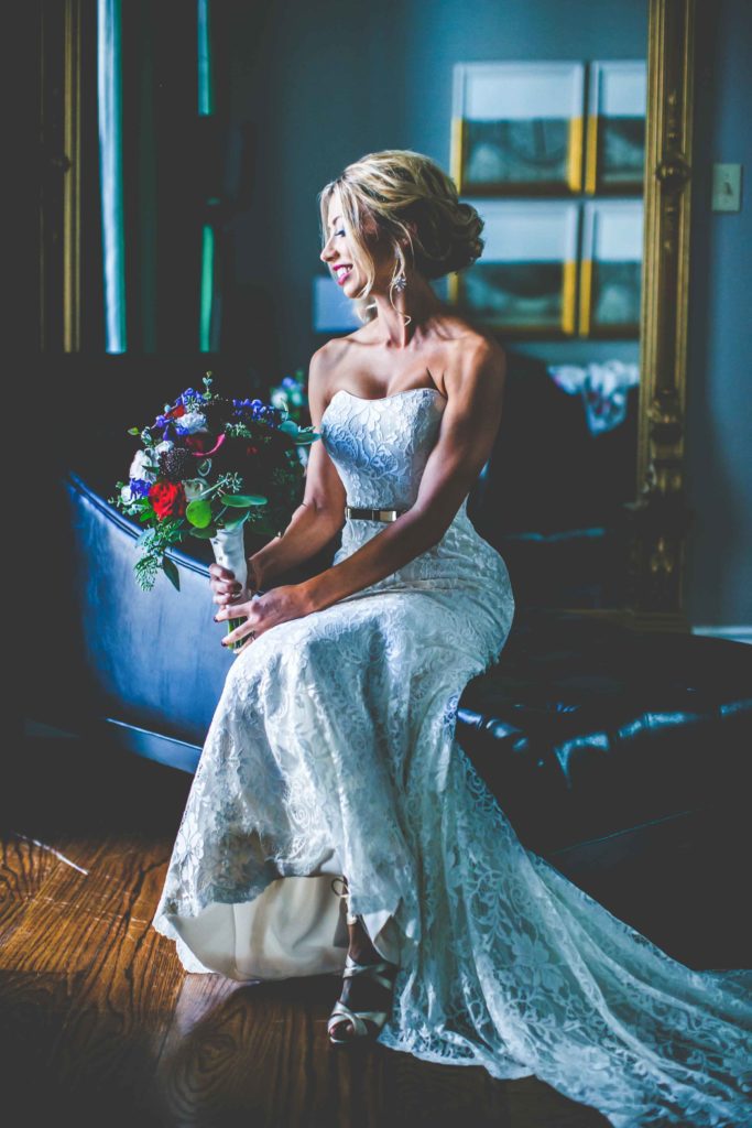A bridal portrait of Sara by a window in her hotel room