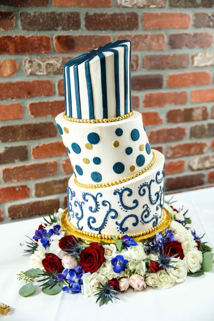 Sara's topsy-turvy wedding cake with blue and gold designs on each layer.
