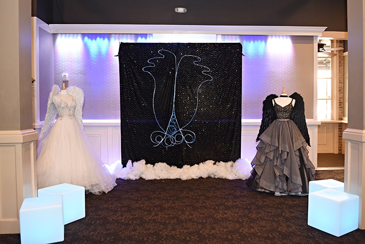 "Neon" angel wing photo opp at the Something Blue Bridal Event in New Orleans. Lighted cube furniture by True Value Rental. Gown, left, Eve of Milady, available at Pearl's Place. Gown, right, Martina Liana Separates, available at The Bridal Boutique by MaeMe.
