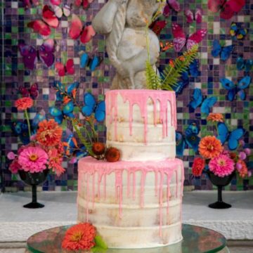This two-tier naked cake with watermelon pink white chocolate “drip” finish by Gambino’s Bakery sits atop a glass base supported by a dozen miniature fish bowls. PHOTOGRAPHER: Brian Jarreau Photography