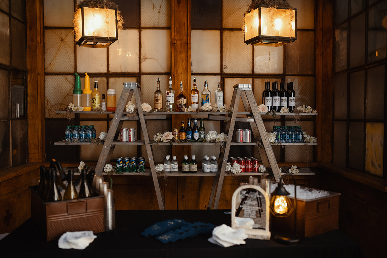The ladder shelf bar back was custom created for Jeanne and Dan's wedding by True Value Rental. Abita and NOLA Blonde beers were displayed in a pirogue. Photo by Dark Roux