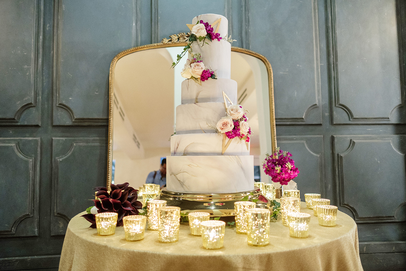 The wedding cake, designed by Chasing Wang, featured six tiers covered with marbled fondant and accented with fresh flowers and geometric decorations.