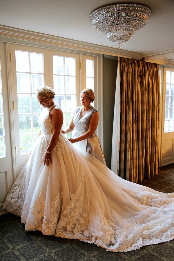 After helping so many other brides find the perfect dress, Courtney's mother, Linda, helps her daughter into her own wedding gown.