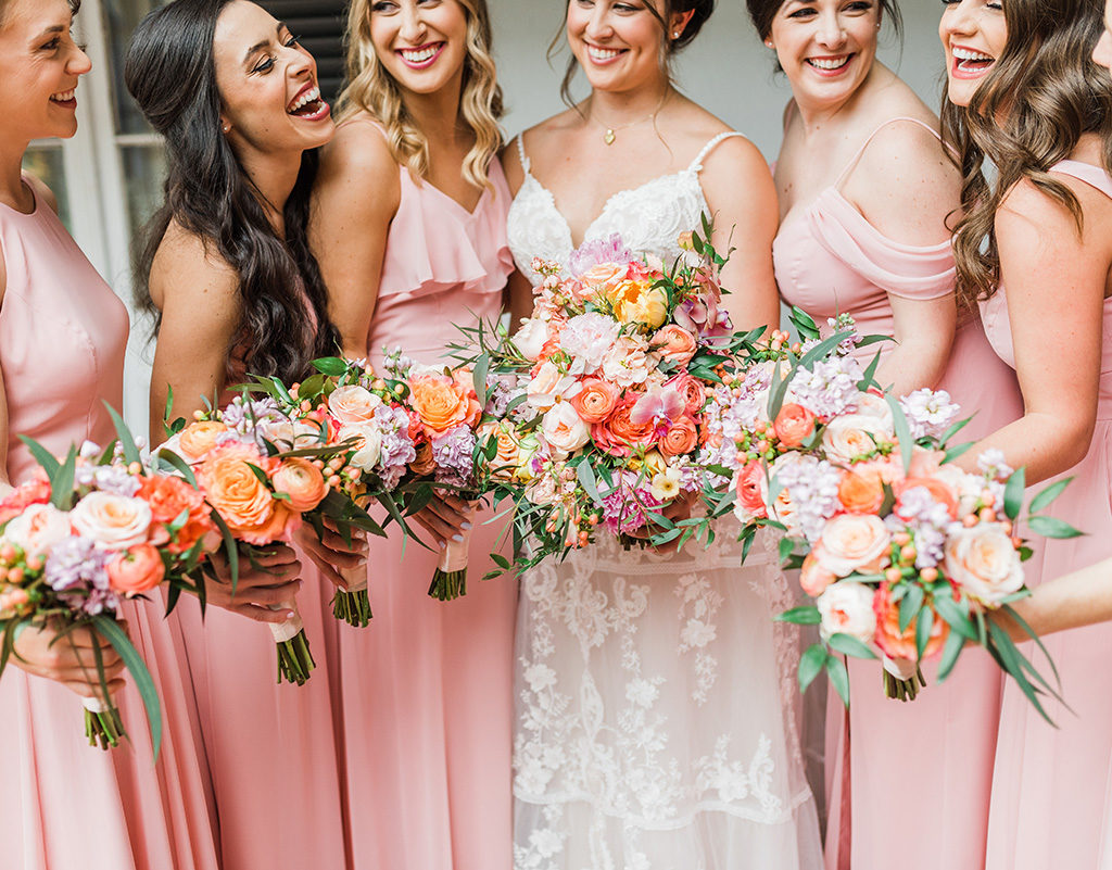 Bride with bridesmaids in coral dresses with colorful bouquets. Gabby Chapin Photography