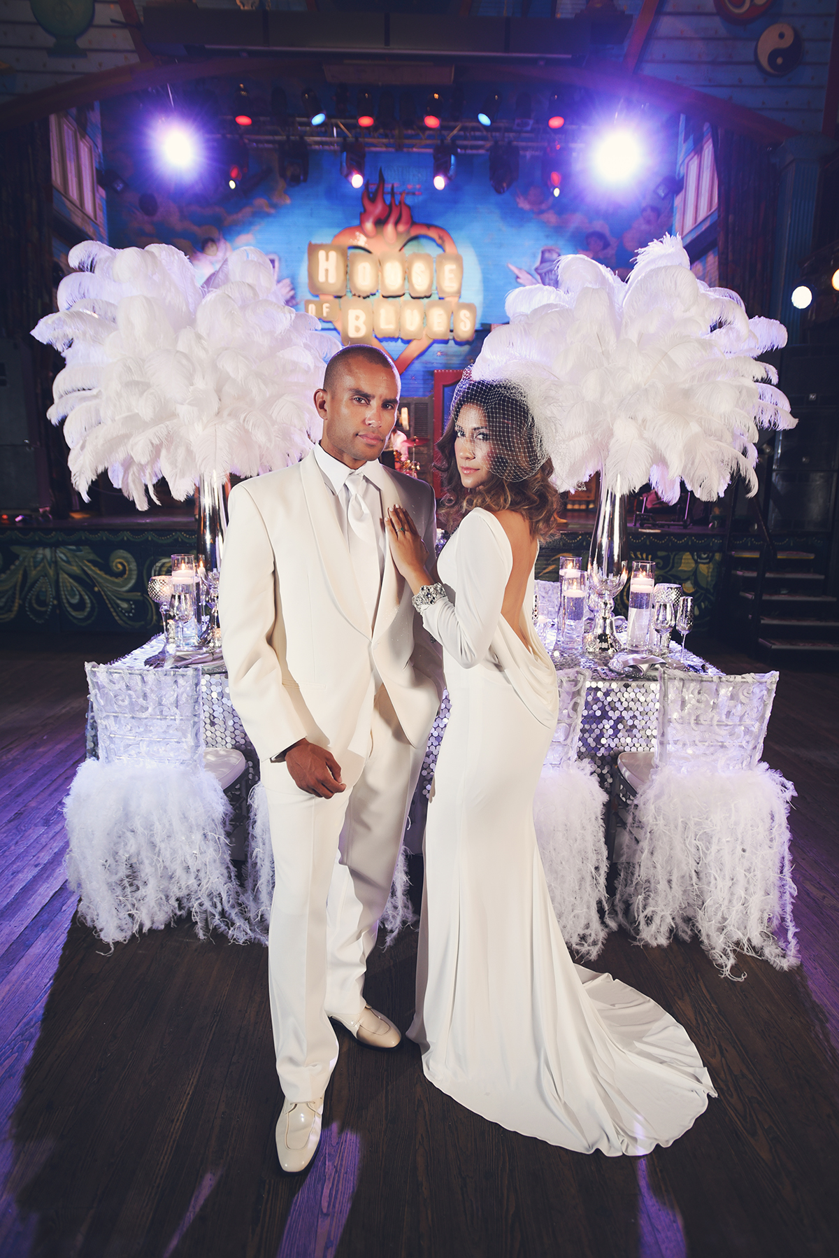 Sexy and chic, Fabiola stuns in a sleek, low-back ivory jersey bridal gown with rhinestone banding at the wrists. Charles' all-white ensemble from John's Tuxedos is perfect for the hot summer nights in New Orleans.