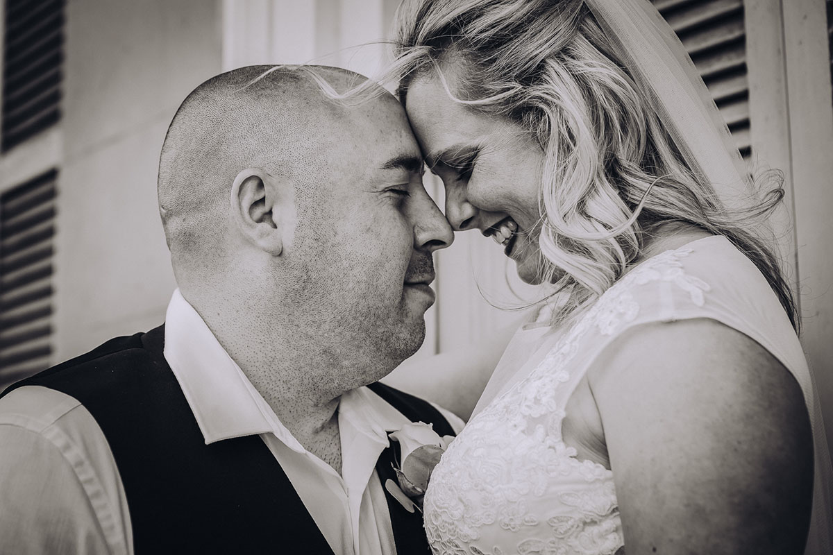 A black and white close up photo of a couple embracing on their wedding day. Photo: Capture Studio Photography