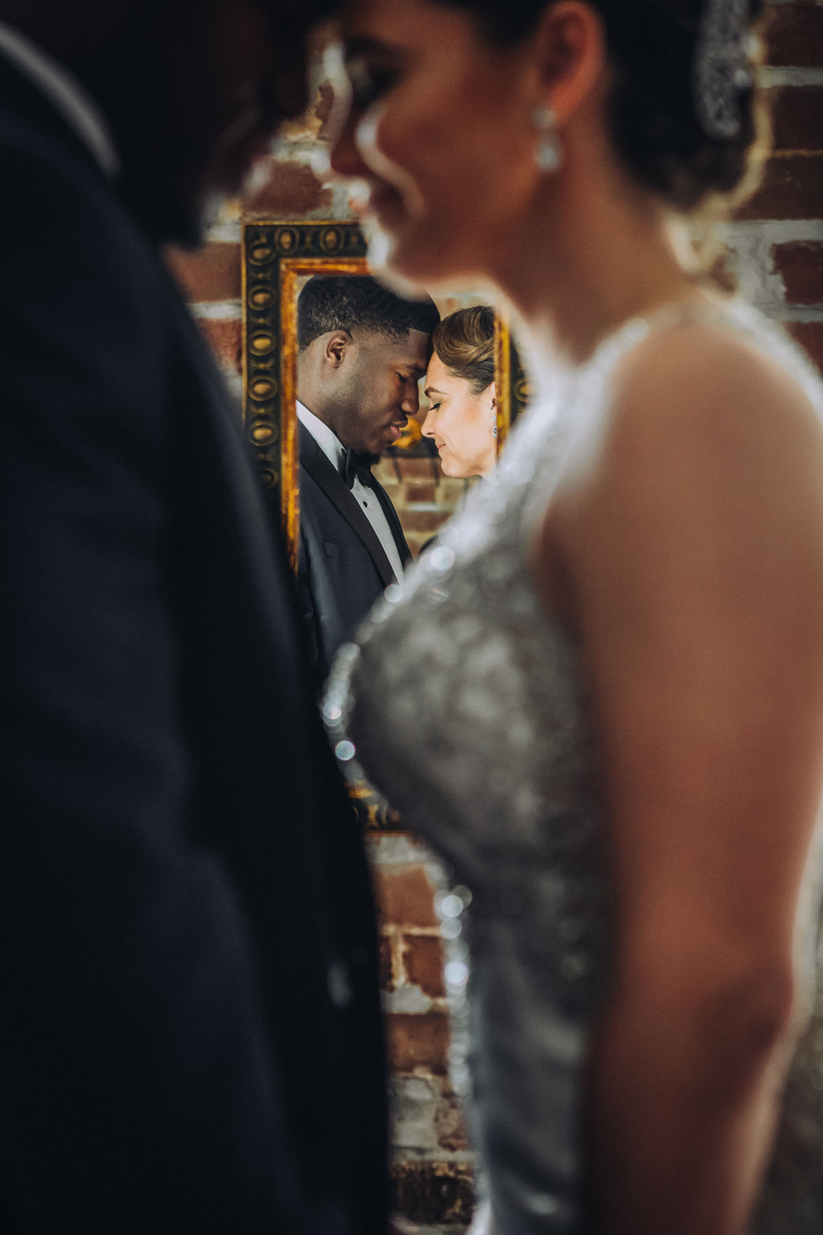 An artistic portrait of a bride and groom with a mirror reflection. Photo: Capture Studio Photography
