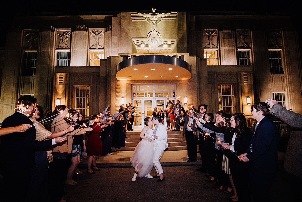brides kissing and guests holding sparklers
