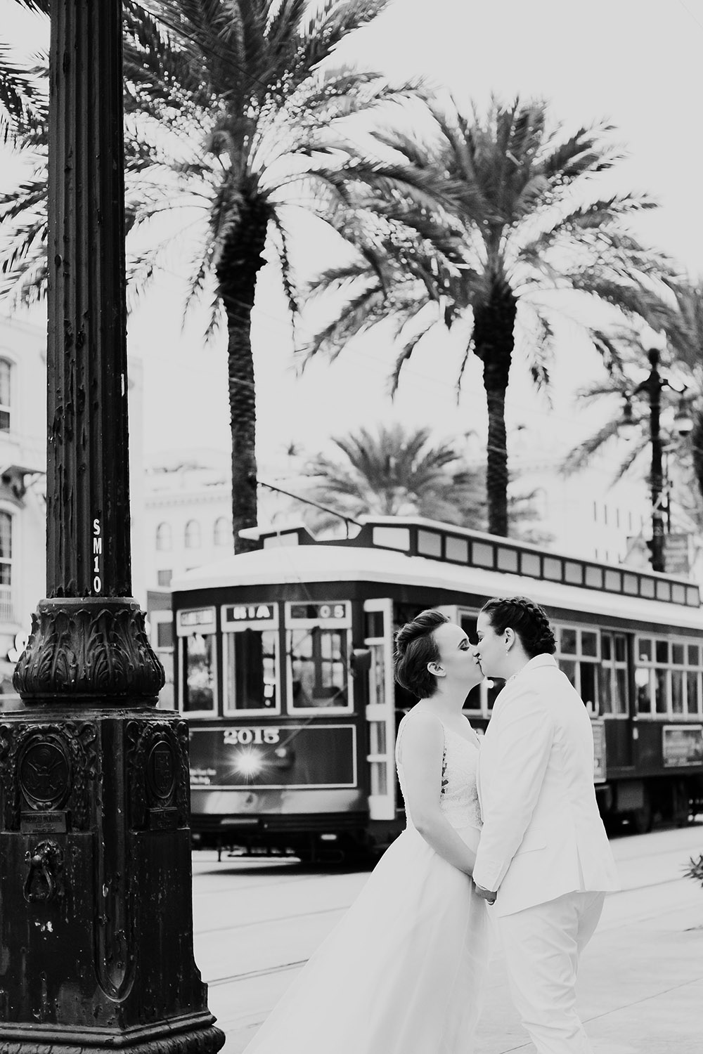 black and white photo of brides kissing new orleans streetcar