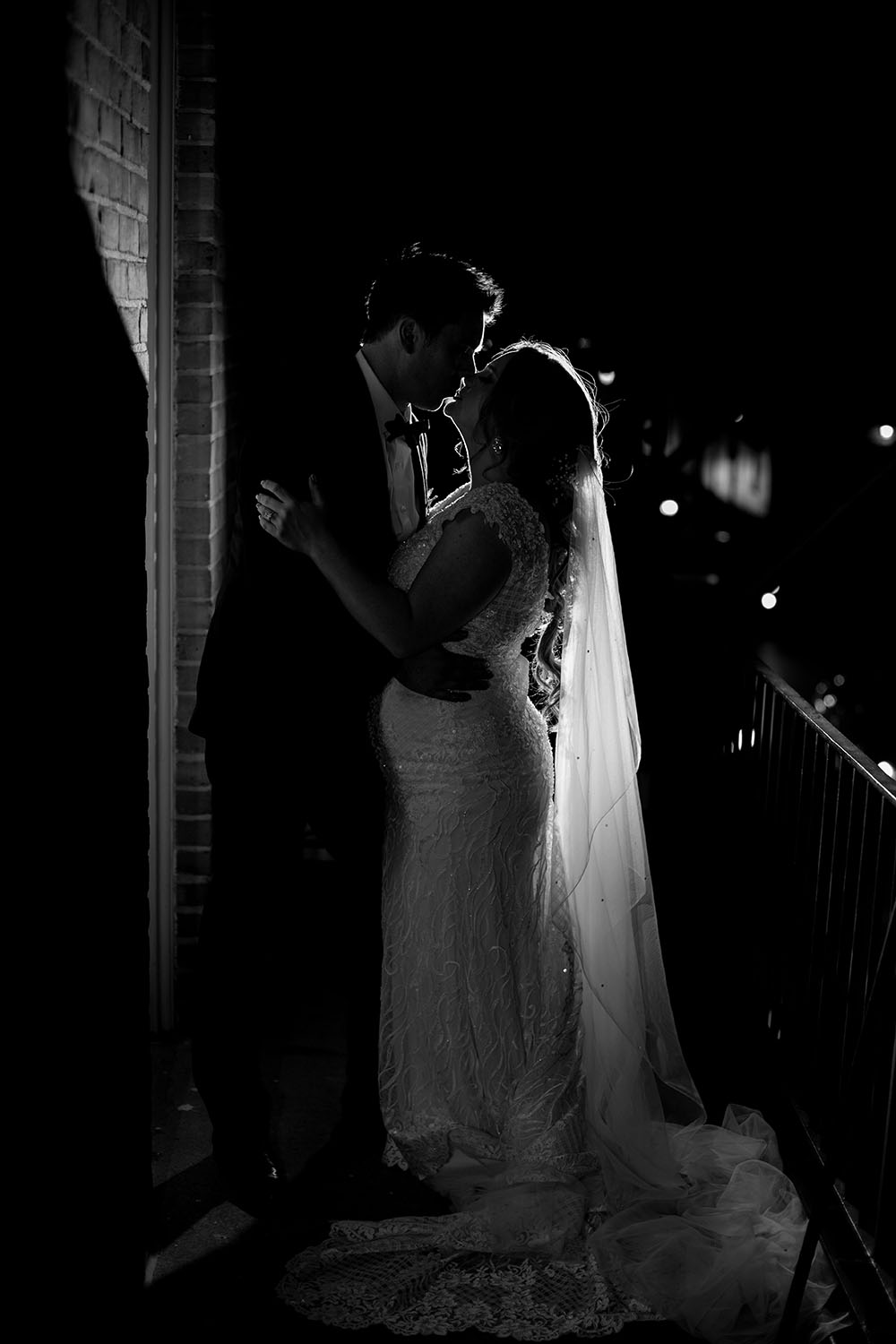 bride and groom embracing in a romantic black and white photo