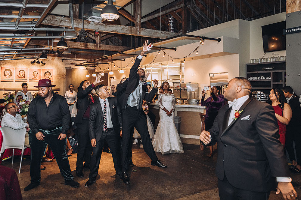 man jumping to catch garter at garter toss new orleans wedding