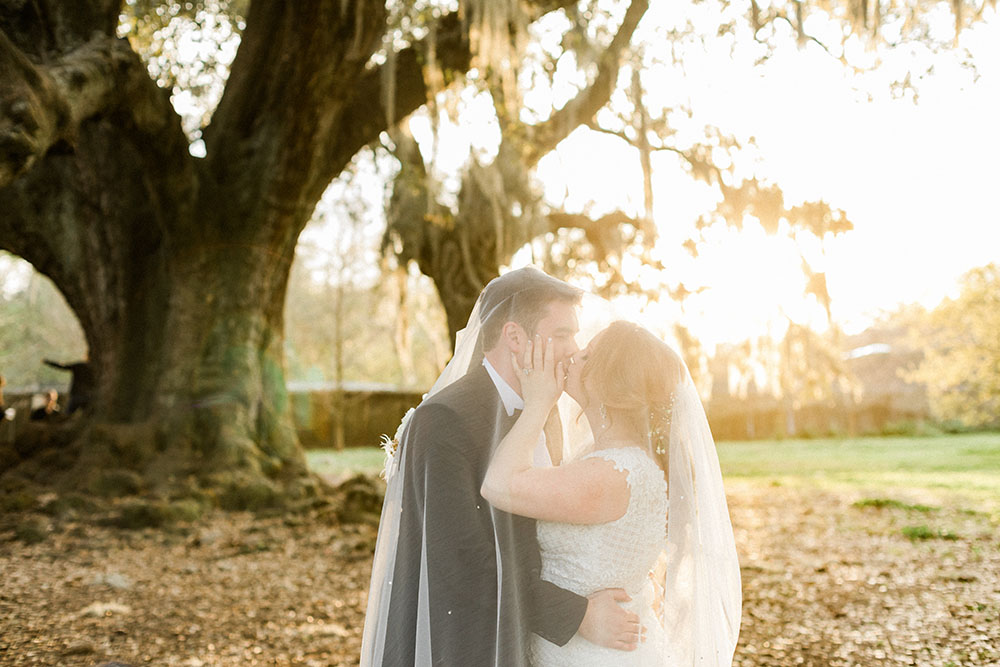 bride and groom kissing under her veil outdoor wedding