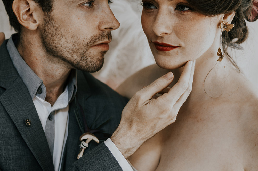 The groom caresses the bride's face.