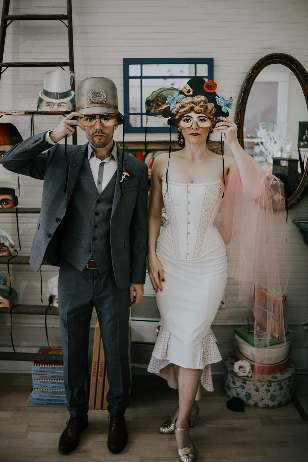 Bride and groom pose with vintage-style masks from L. Delaney's Imaginarium