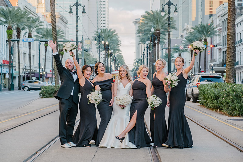 A bride and her bridesmaids pose on Canal Street in New Orleans | Photo: Studio Tran
