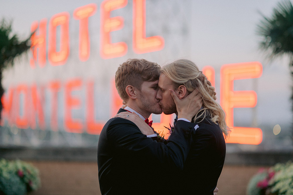 Grooms kiss on the Hotel Monteleone Rooftop in New Orleans