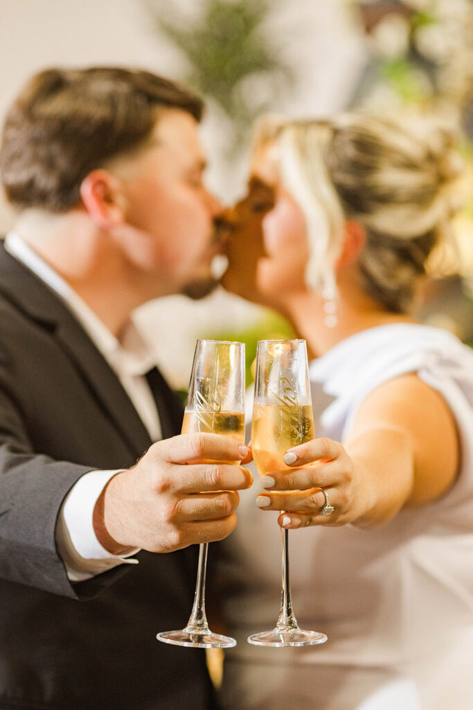 Champagne toast close-up as the newlyweds clink glasses during their reception.