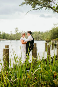Romantic dockside portrait of the bride and groom embracing by the water.