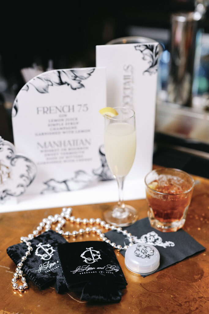 Signature cocktail display featuring a French 75 and Manhattan menu with elegant black-and-white bar signage.