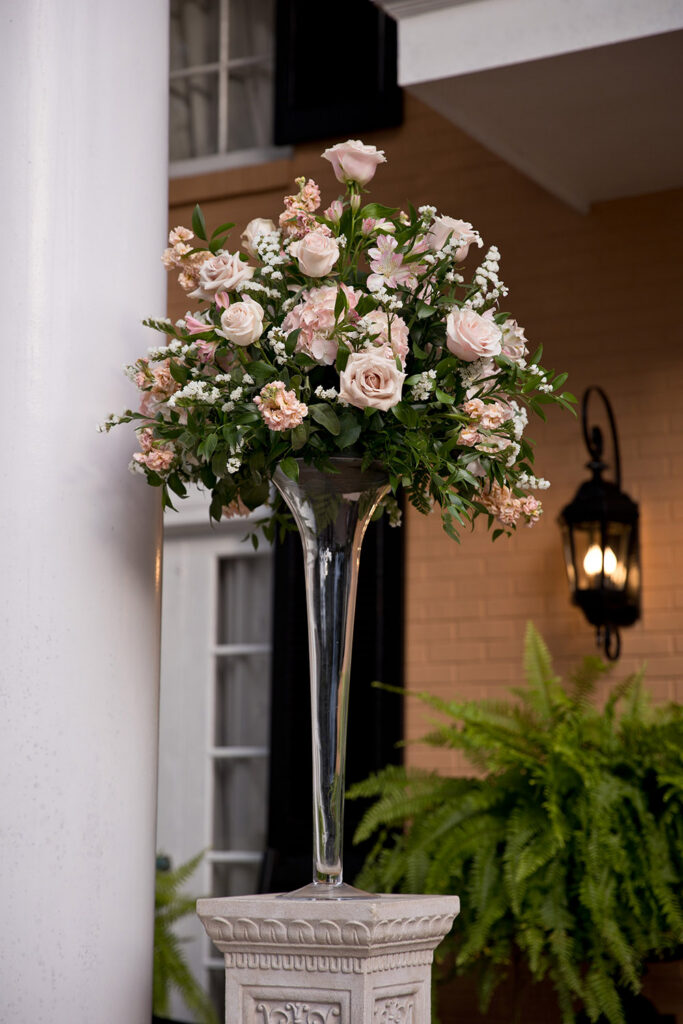 Tall pink and blush floral arrangement on pedestal at outdoor wedding venue in Mobile, Alabama