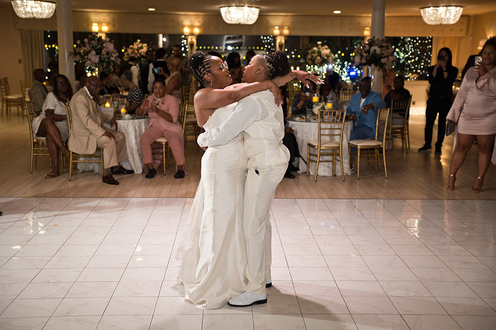 Couple sharing first dance during indoor wedding reception in Mobile, Alabama with guests watching