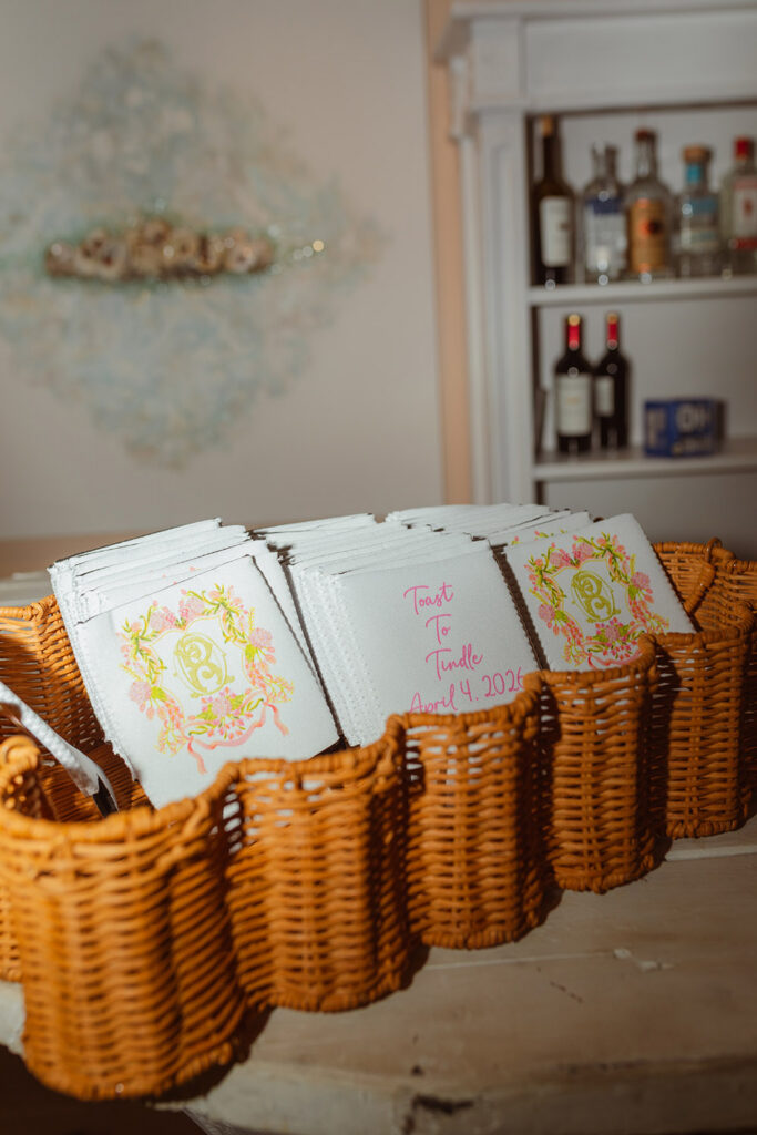 Personalized cocktail napkins displayed in wicker baskets feature the couple's monogram and wedding date.