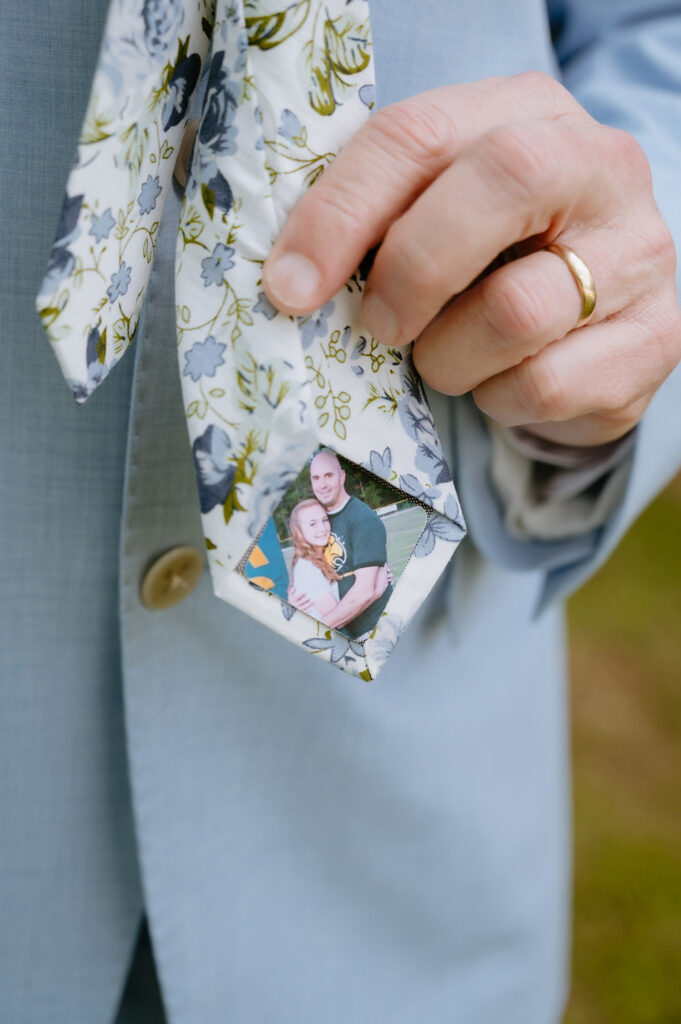 Close-up of the groom's floral tie featuring a custom photo sewn into the tip.