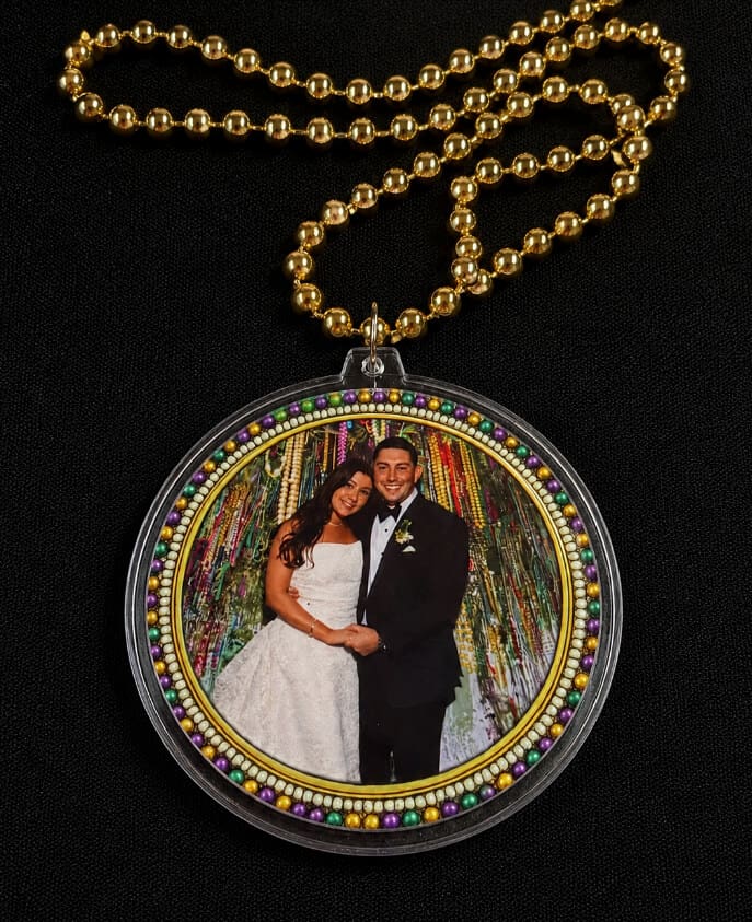 Gold beaded chain necklace with a circular pendant showing a joyful bride and groom, framed by colorful beads and festive colors.