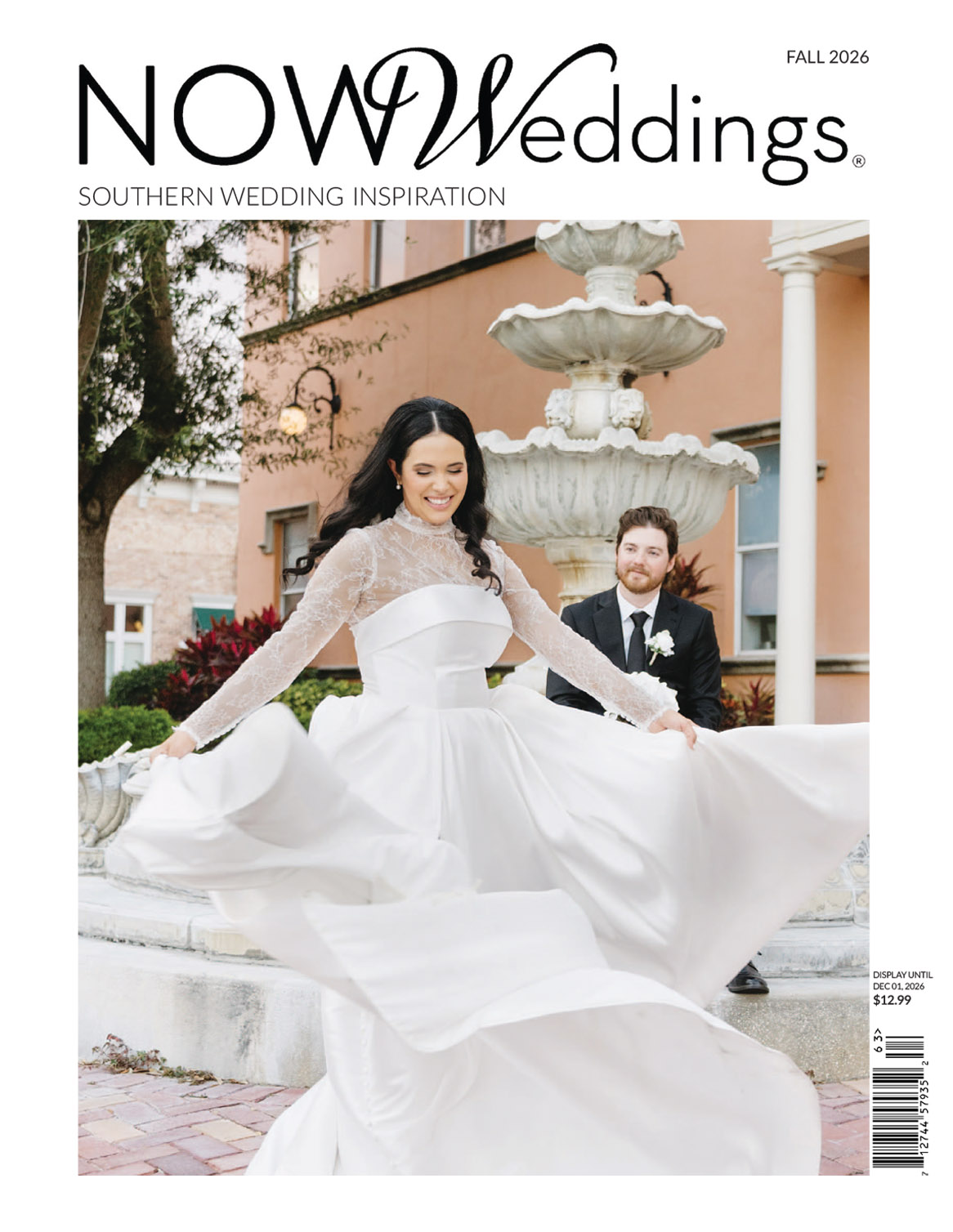 Bride twirls in white gown before a fountain, groom smiles behind, outside pastel building on NOW Weddings magazine cover.