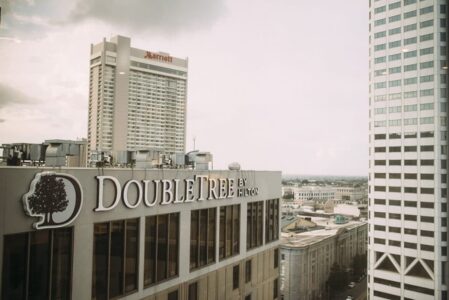 Downtown skyline with DoubleTree by Hilton in front and a tall Marriott hotel behind, beneath a cloudy sky.