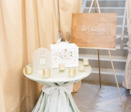 Elegant Louisiana wedding table with pale green cloth, gold candles, white box, and custom Chaissons sign.