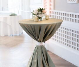 Sage green table with floral centerpiece and gold candles in bright room with white lattice—New Orleans wedding inspiration.