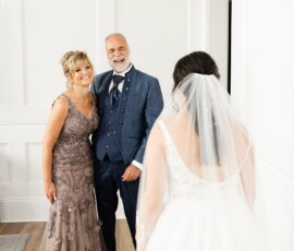 A smiling couple in formal wear faces a bride in a white gown and veil, showcasing a classic New Orleans wedding.