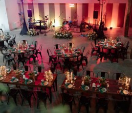 Elegant Louisiana wedding venue with candlelit tables, warm lights, and a live music stage in the background.