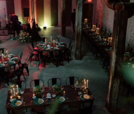 Rustic event space with long wooden tables, candles, and black chairs—ideal for a stylish New Orleans wedding.