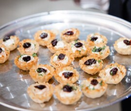 Silver tray with phyllo pastry cups filled with creamy cheese, dark jam, and herbs—ideal for a New Orleans wedding.