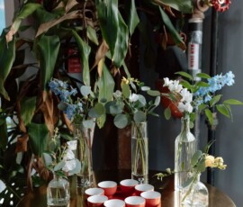 Gold round table with vases, white bowls, greenery, and chic industrial decor for a stylish New Orleans wedding.