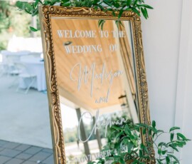 Gold-framed mirror with vines welcomes guests to Madison and Chapman’s Louisiana wedding, dated November 4, 50.
