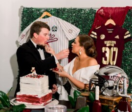 Bride and groom feed each other red velvet cake at their Louisiana wedding, with Mississippi State jerseys in the background.