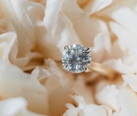 Diamond engagement ring nestled in creamy white flower petals, ideal for a romantic Louisiana wedding ceremony.
