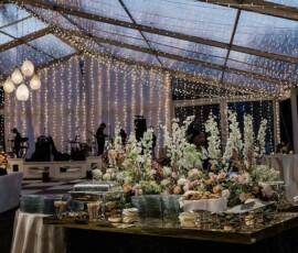 Elegant New Orleans wedding under a clear tent with string lights, set tables, and a band ready for an unforgettable evening.