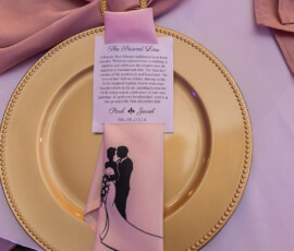 Gold plate with pink napkin, couple silhouette, and personalized Second Line tradition card for a 06.01.2024 wedding.