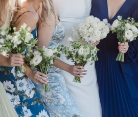 Women in floral and solid dresses hold white and green bouquets, their faces out of frame—timeless Louisiana wedding inspiration.