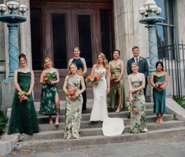 Wedding party poses on stone steps after a New Orleans ceremony; bride in white, bridesmaids in green, one suited groomsman.
